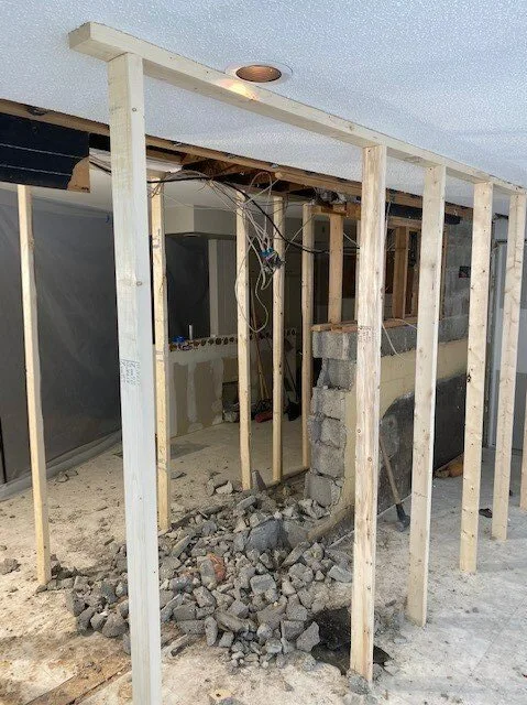 Temporary timber shoring supporting the ceiling beside the kitchen wall